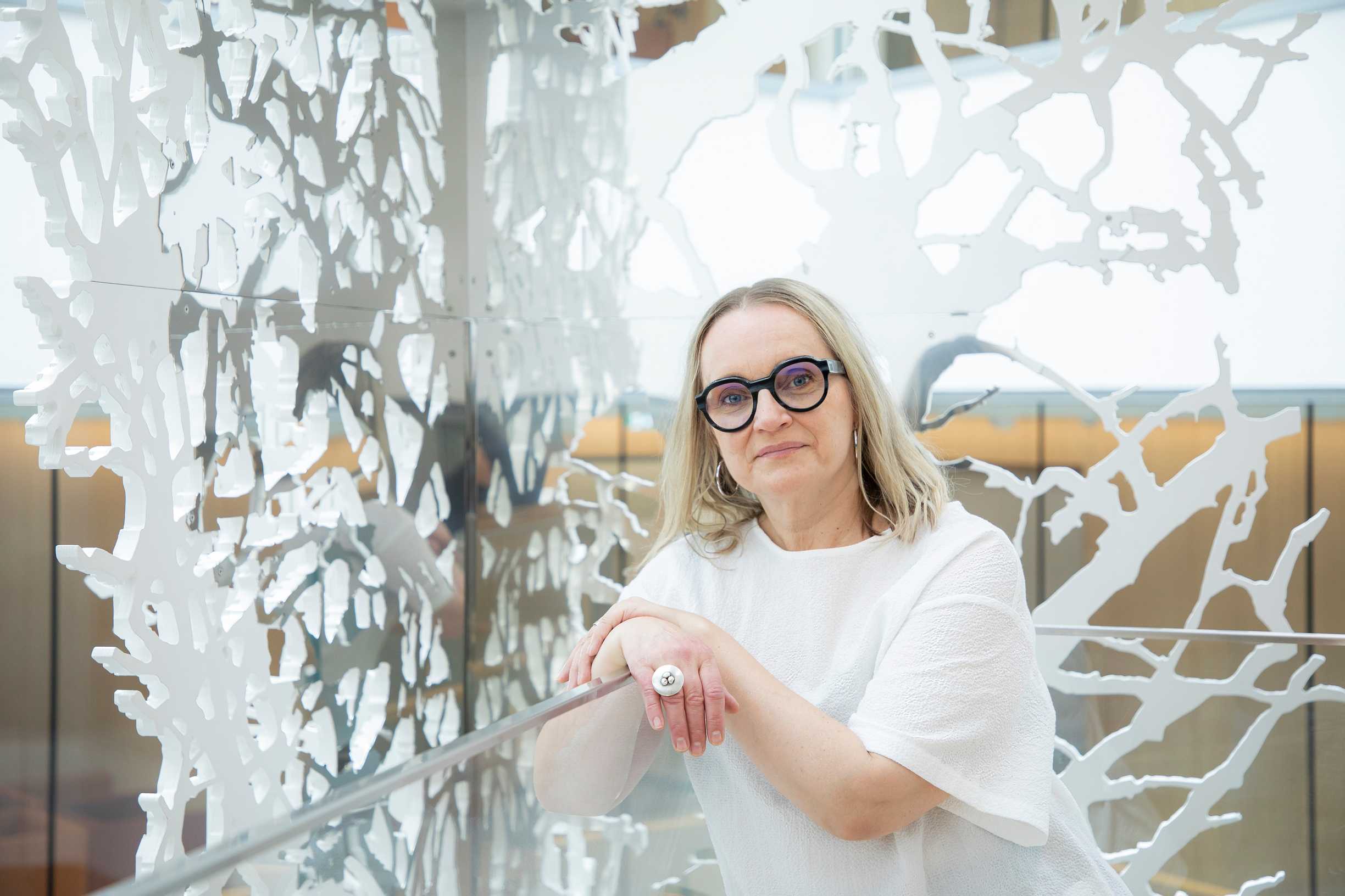 Helena Hietanen taustallaan taideteos