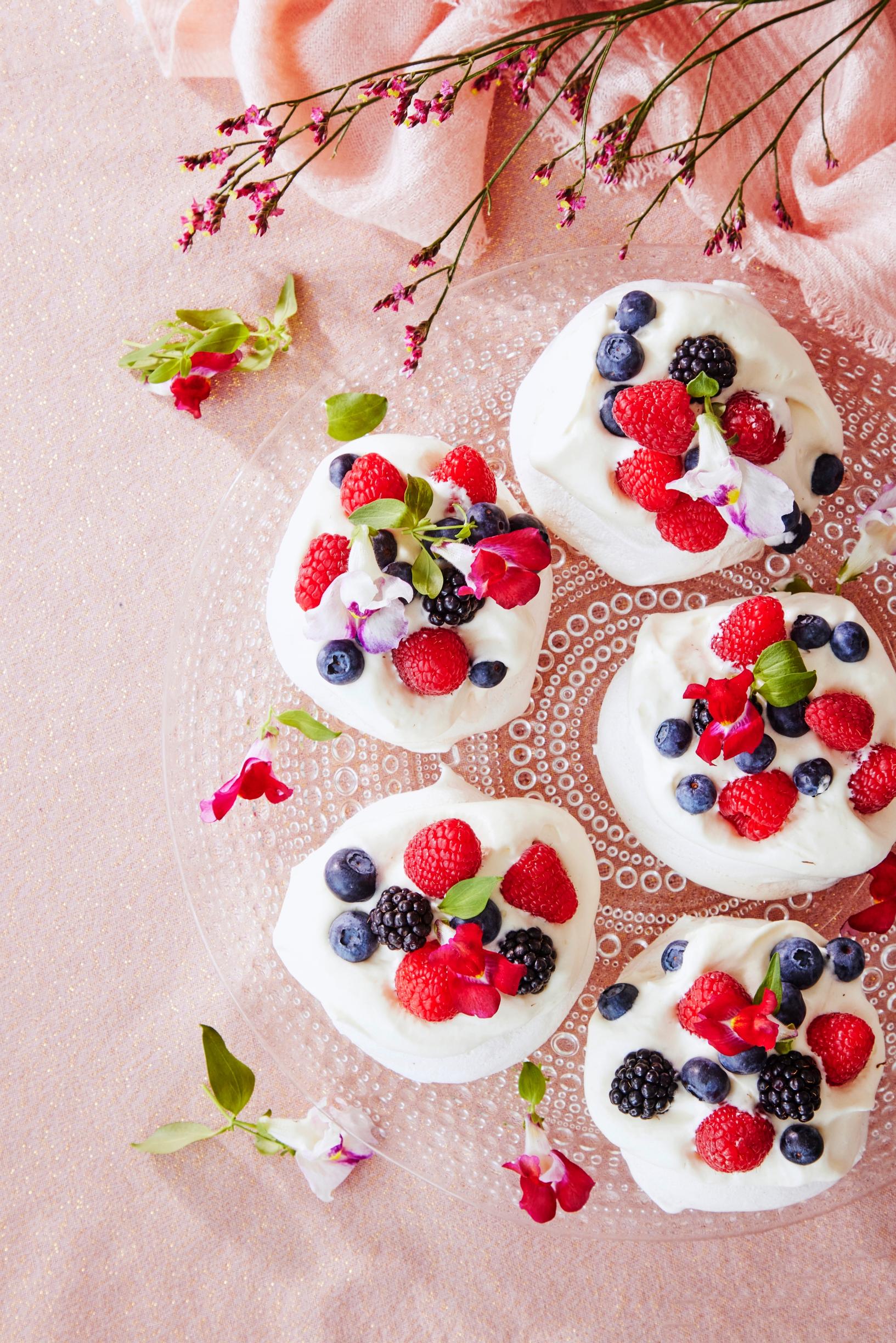 Pavlova-leivoksia, joissa vadelmia ja mustikoita päällä