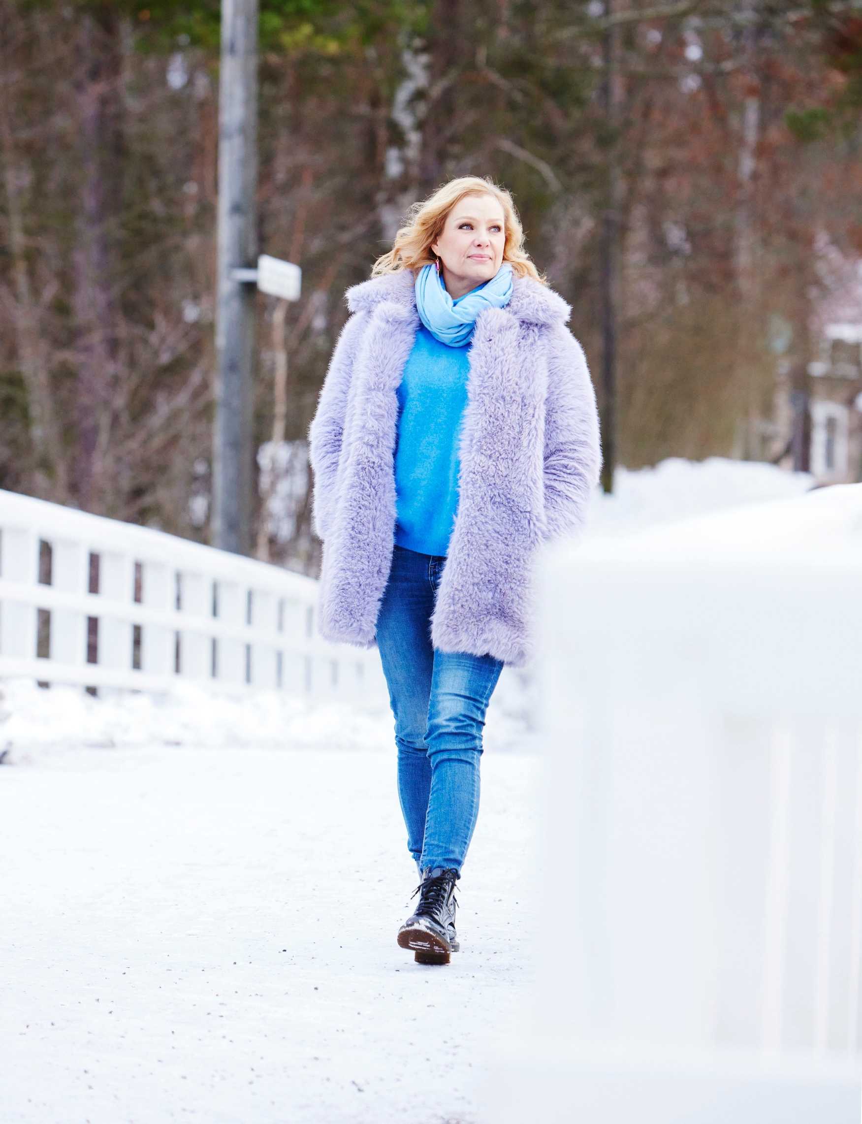 Laura Tuomarila kävelee ulkona lumisessa maisemassa